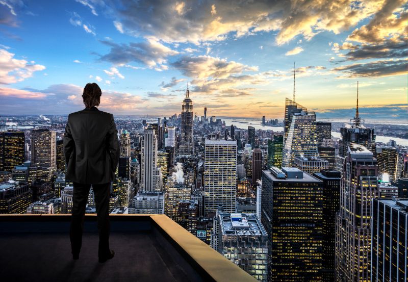 businessman watching the new york city on the rooftop of skyscraper